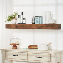Floating walnut shelf with farmhouse design, holding kitchen decor on a white wall.
