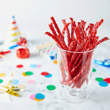 Clear cup filled with red striped strawberry-flavored twist candy sticks