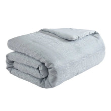 Folded light grey jacquard comforter with subtle woven texture