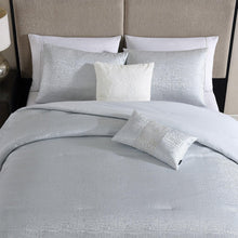 Light grey jacquard comforter set with three shams and two folded decorative pillows