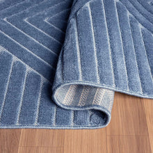 Indoor area rug corner detail in denim blue with stitched binding