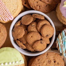 Bowl of bite-size chocolate chip cookies with more cookies around it