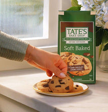 Soft baked dark chocolate chunk cookies bag with hand holding a cookie on plate