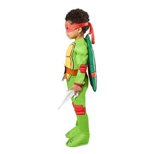 Toddler turtle costume with red headband, green jumpsuit, brown belt, shell backpack