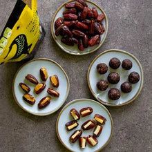 Pitted dates on small plates, with sliced pieces and whole dark dates