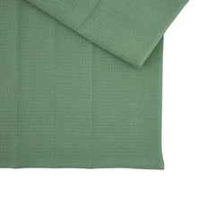 Green terry kitchen towel, folded with textured surface and straight hem.