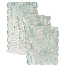Quilted green-and-white fabric table runner with scalloped border and stitched wave pattern