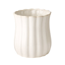 White stoneware utensil holder with fluted sides and scalloped rim