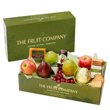 Green gourmet gift box open with fruit assortment: apples, pears, chocolate, crackers