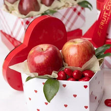 Apple and cranberry-filled heart-patterned gift box cup with pears behind