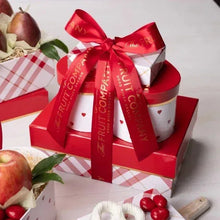Fruit gift tower with red ribbon and heart-patterned cups, apples and pears