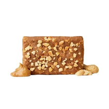 Peanut butter protein bar with chopped nuts on top, dark caramel color