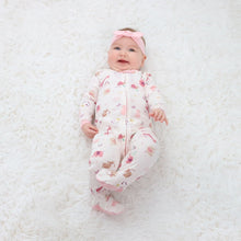 Baby wearing safari-print pink-trim sleepbag with matching cap