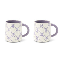 Pair of purple-lined white stoneware mugs with bow pattern and side handles
