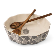 Leaf-pattern ceramic serving bowl with cream interior and wooden serving fork and spoon