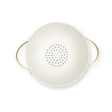 Cream colander with gold handles, perforated sides and base.