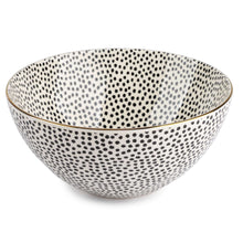 Large ceramic serving bowl with black dot pattern and gold rim, white interior