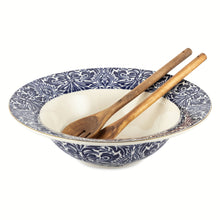 Navy and white patterned ceramic serve bowl with two wooden utensils