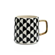 Black and white geometric stoneware mug with gold-tone handle