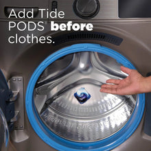 Laundry detergent pod resting in washing machine drum with blue dispenser ring