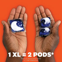 Laundry detergent pods in hands, blue-and-white capsules, 2 pods shown