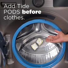 Tide PODS detergent pacs placed in washer drum before adding clothes.