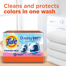 Laundry detergent pods box next to folded towels, claiming color protection in one wash.