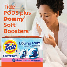Laundry detergent pods box with Tide and Downy Soft Boosters, April Fresh, near woman.