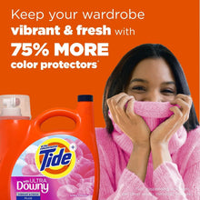 Orange Tide Ultra Downy liquid detergent bottle beside folded pink sweater