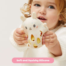 Soft silicone baby rattle with bunny face, held by an infant