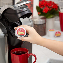 Tim Hortons Original Blend K-Cup pod held near coffee brewer, white pod label