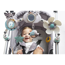 Baby in stroller with overhead play arch, hedgehog, cow, flower, star and fish toys