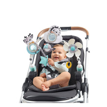 Baby smiling in stroller with hanging toy arch, flower, cow, hedgehog, star and fish