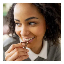 Toblerone milk chocolate bar held by a smiling person