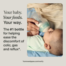 Anti-colic baby bottle with teal reservoir and slow-flow nipple held near baby