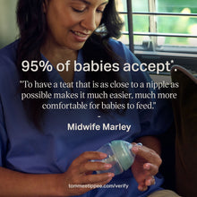 Parent holding an anti-colic baby bottle with teal slow-flow nipple