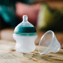 Tommee Tippee silicone baby bottle with teal top and clear nipple, rounded white body