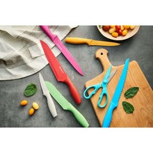 Colorful kitchen knives with green and blue shears on a wooden cutting board