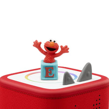 Elmo musical audio figurine with blue base and letter E on portable speaker top.
