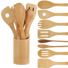 Wooden utensil holder with wooden spoons, spatulas, and cooking tongs