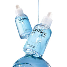 Two light-blue hyaluronic acid serum bottles with white droppers and splash
