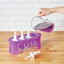 Purple pop ice mold tray with four upright animal forms, with pitcher pouring liquid