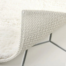 White bath mat corner with textured non-slip backing and plush top