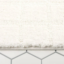 White plush bath mat surface with low, dense tufted pile and flat edge