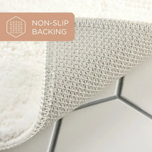 White bath mat corner showing non-slip textured backing