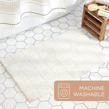 White tufted bath mat on floor tiles, plush pile with stitched edge