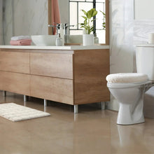 White round bath mat and white tufted bath mat in bathroom setting