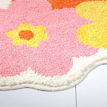 Bath mat close-up with pink floral petals and yellow flower centers