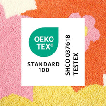 Close-up of multicolor floral bath mat texture with pink, orange, and yellow sections