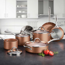 Nonstick cookware set on countertop with copper pots and stainless-steel lids and pans
